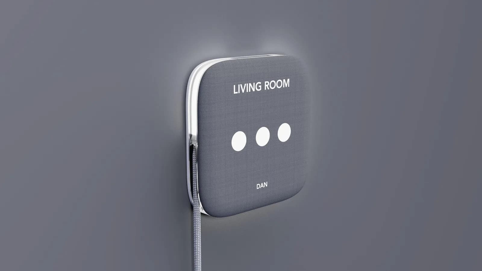 Render of a fabric-covered square wall unit labelled Living Room and Dan, with three white dots on its face and a cord running down the wall