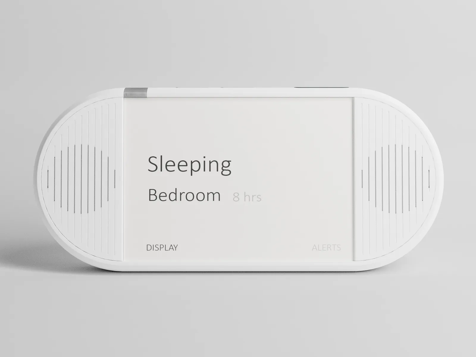 The caregiver display from the front: a white pill shape with a speaker grille at each end and an e-ink card reading Sleeping, Bedroom, 8 hrs