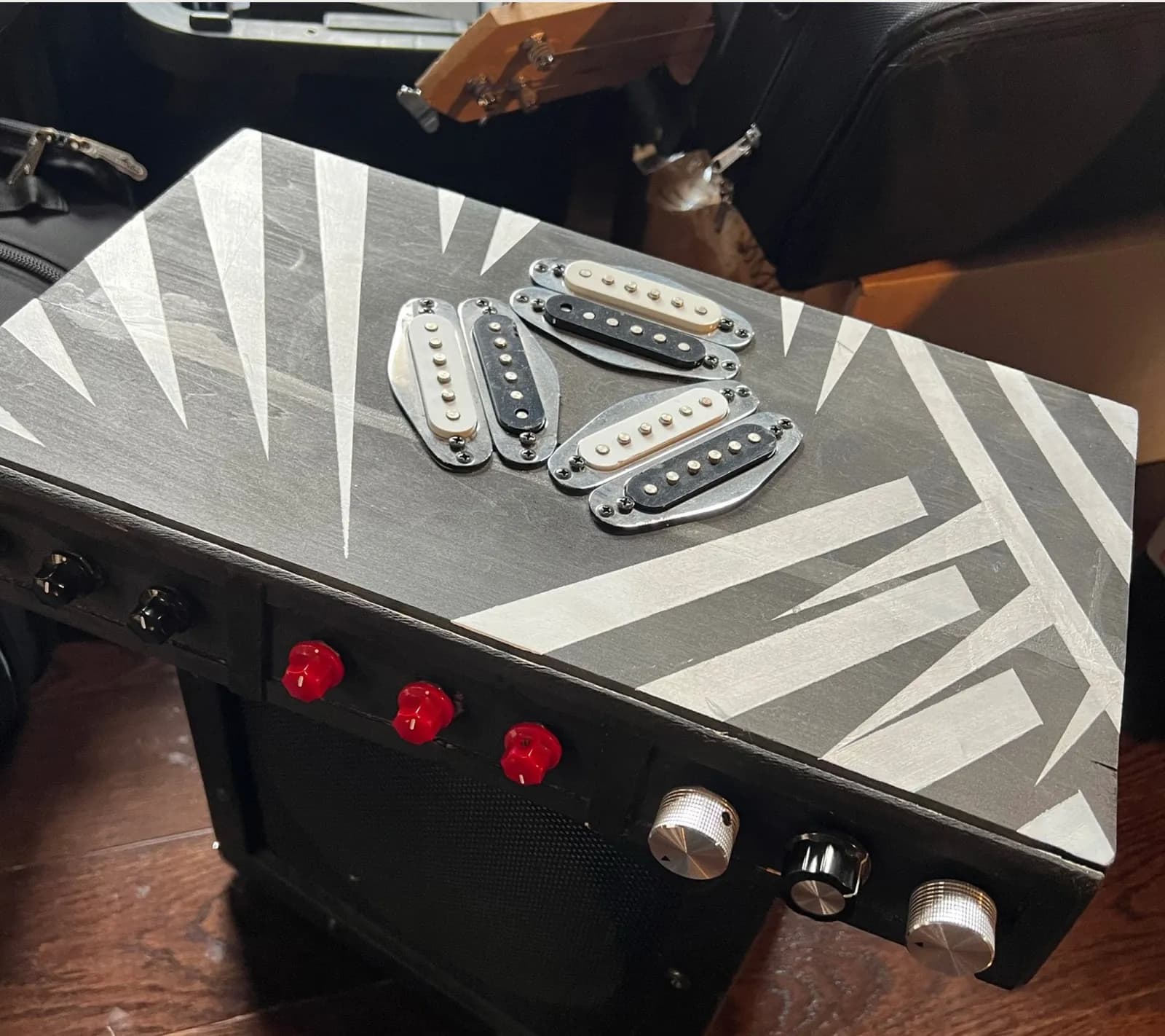 Alexandra's original box: hand-painted black with silver triangle stripes, guitar pickups mounted on the lid, red and silver knobs on the front