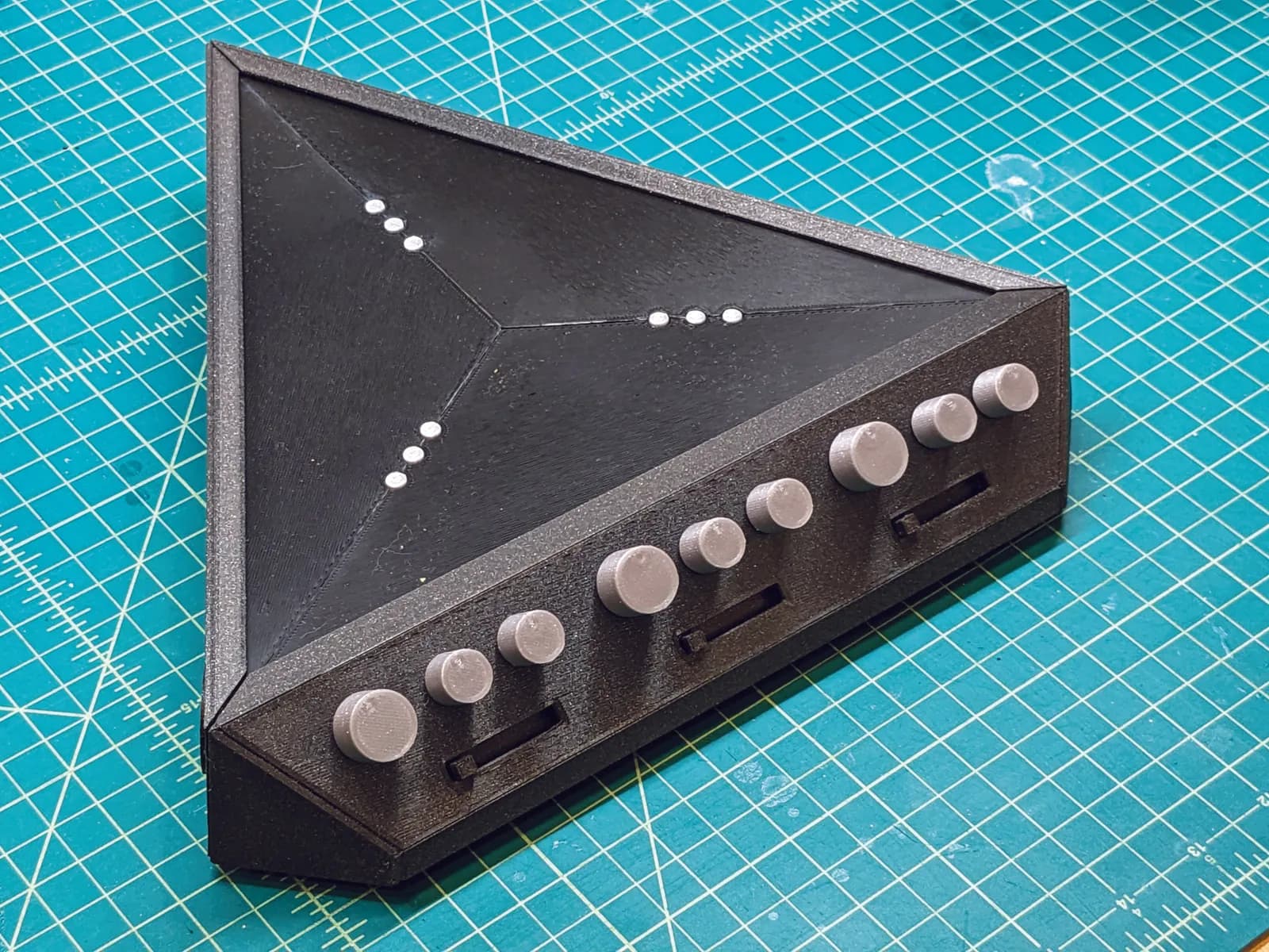 3D printed prototype with placeholder knobs on a cutting mat