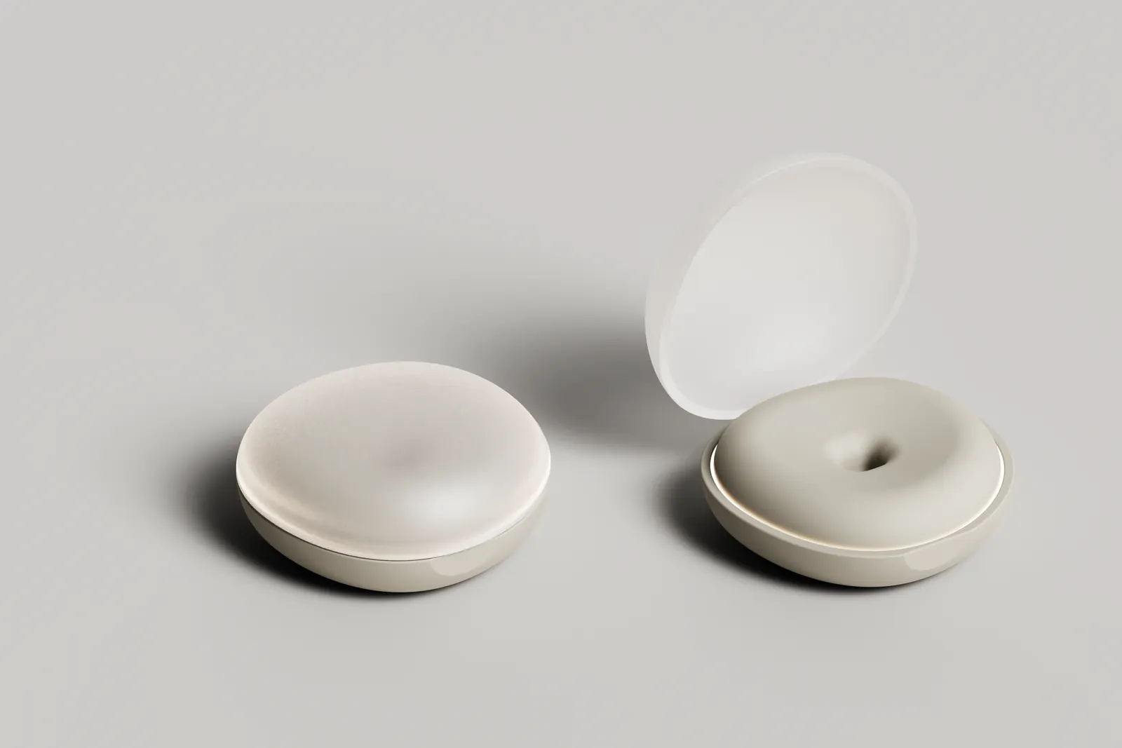 Render of a smooth oval pebble base station, closed and open, with a frosted lid and a dimple that seats the wearable