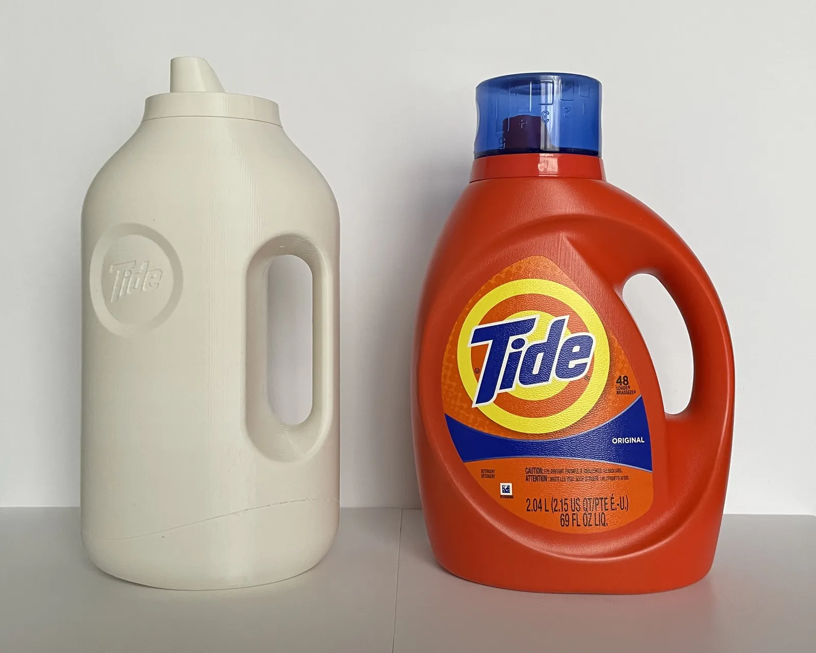 3D print of the loop-handle bottle next to the current Tide bottle
