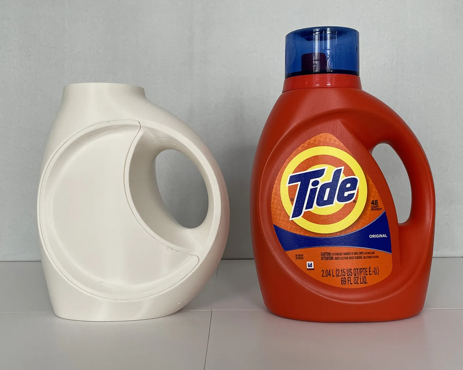 3D print of the ring-handle bottle next to the current Tide bottle