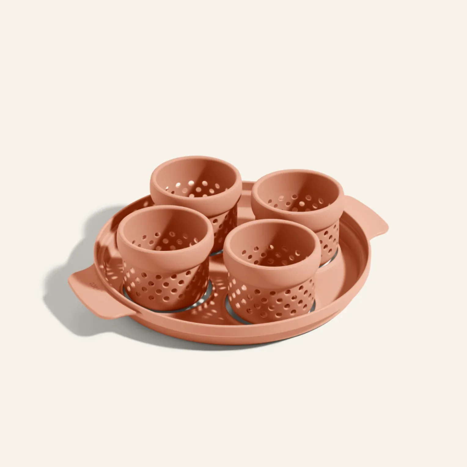Pink egg poacher tray with four perforated cups