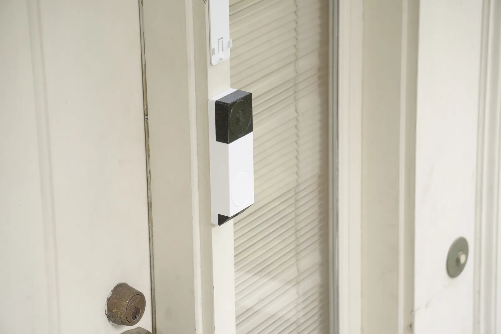 The 3D print taped to a white door frame beside a glass door